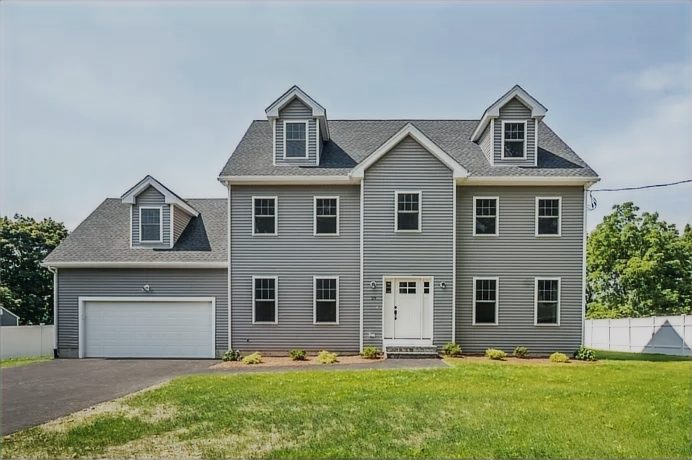 Newly built grey colonial-style home with an attached garage